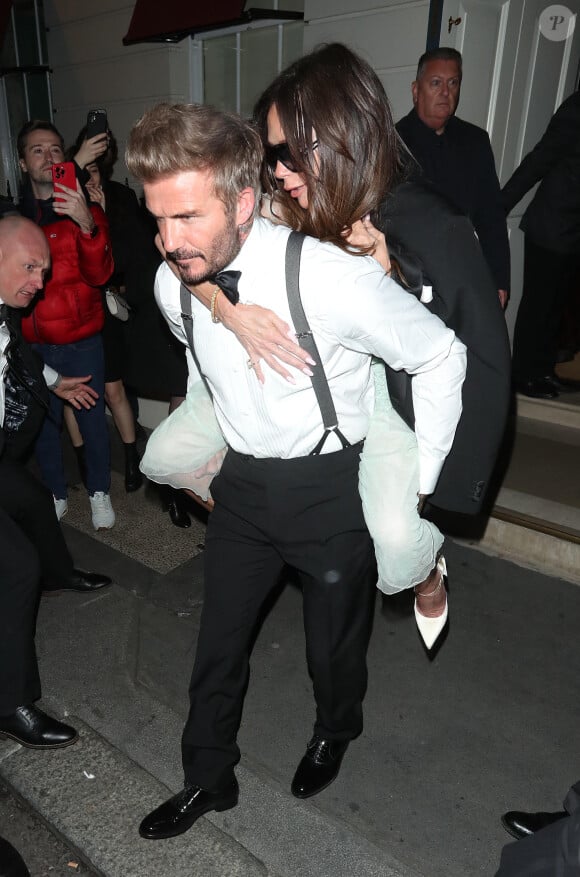 David Beckham porte sa femme Victoria Beckham sur son dos, à la sortie de la soirée de son 50ème anniversaire au club Oswald's à Londres, le 20 avril 2024. Arrivée munie de béquilles, Victoria Beckham a quitté sa fête d'anniversaire vers 2h30 du matin, portée par son mari depuis presque 25 ans.