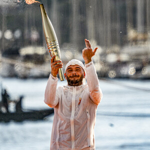 Le rappeur Jul embrase le chaudront olympique lors de la cérémonie d'arrivée de la flamme olympique au Vieux-Port de Marseille, France, le 8 mai 2024, avant les Jeux olympiques et paralympiques de Paris 2024. Le transfert de la flamme à terre d'un navire de haut du XIXème siècle marquera le début du relais de la torche olympique de 12 000 kilomètres (7500 milles) à travers la France. © Sandrine Thesillat/Panoramic/Bestimage