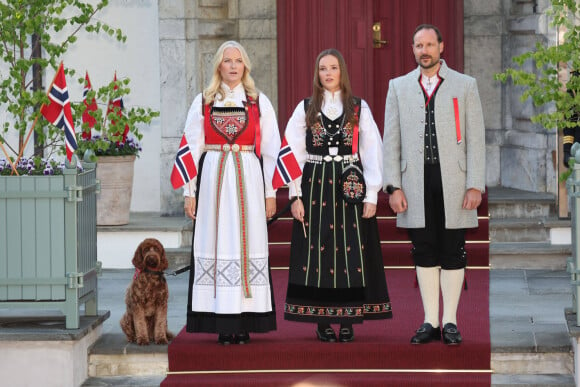 Unis, les futurs monarques de Norvège doivent hélas faire face à la maladie. 
Le chien Molly, La princesse Mette-Marit de Norvège, La princesse Ingrid Alexandra de Norvège, Le prince Haakon de Norvège - La famille royale norvégienne, en costume traditionnel, assiste au début de la parade des enfants devant la villa Skaugum à Asker, à l'occasion de la fête nationale, le 17 mai 2024.