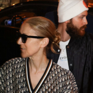 Céline Dion salue la foule de fans à sa sortie de l'hôtel à Paris.