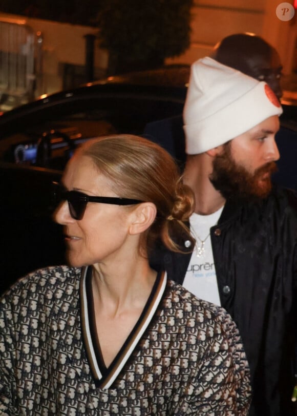 Céline Dion salue la foule de fans à sa sortie de l'hôtel à Paris.