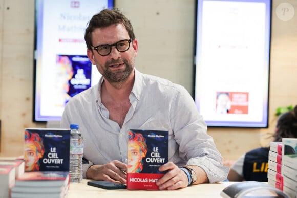 Désormais, ses romans lui permettent de vivre sereinement, mais il n'oublie pas les épreuves qu'il a affrontées.
Nicolas Mathieu signe son livre au Festival du livre de Paris, au Grand Palais éphémère, le 13 avril 2024. Thibaud Moritz/ABACAPRESS.COM