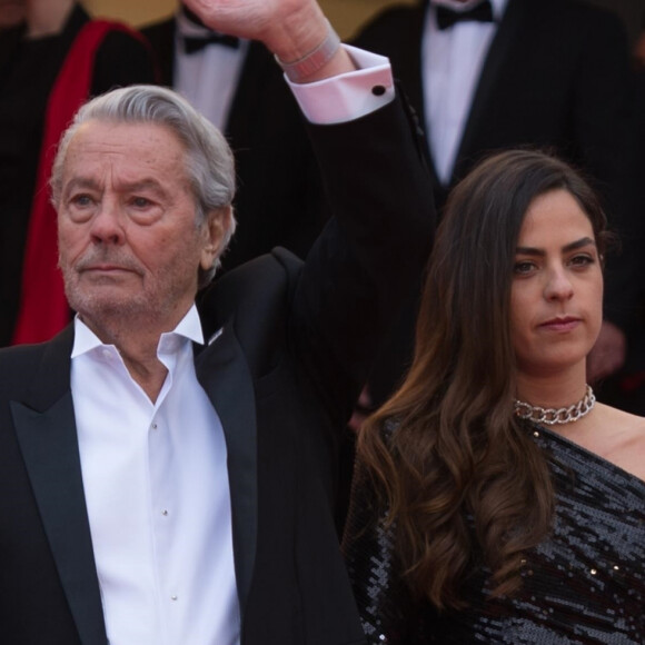 Alain Delon (Palme d'Or d'Honneur du 72ème festival de Cannes avec un badge Paris Match d'une ancienne couverture du magazine titrant "Alain Delon, mes deux amours, Rosalie et Anouchka) et sa fille Anouchka (Robe Elie Saab) - Montée des marches du film "A Hidden Life" lors du 72ème Festival International du Film de Cannes. Le 19 mai 2019