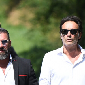 Anthony Delon et son demi-frère Alain-Fabien découvrent les hommages devant les grilles de la propriété de Douchy, quelques heures avant les obsèques de leur père, A.Delon, le 24 août 2024.