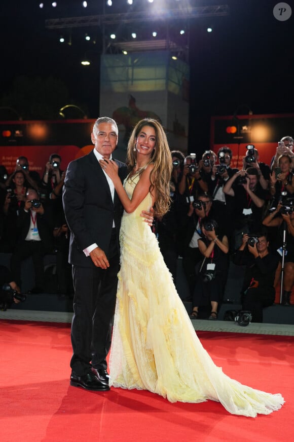 Amal Clooney était solaire dans une magnifique robe en dentelle signée Atelier Versace. 
George Clooney et sa femme Amal Clooney à la projection de "Wolfs" lors du 81ème festival international du film de Venise, la Mostra le 1er septembre 2024. © Lucia Sabatelli / Bestimage