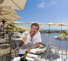 Bernard Montiel, présentateur et animateur radio pose sur la terrasse du restaurant "La Corniche" en dégustant un verre de vin blanc du château Smith Au Lafitte et quelques huïtres. . La Teste-de-Buch Pyla-Sur-Mer, le 14 juillet 2017. © Thibaud Moritz / Bestimage