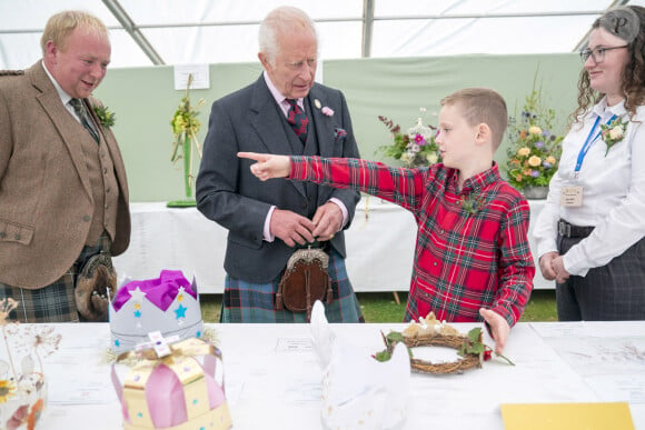 Charles III discutant avec Oliver Keith, 8 ans, d'une couronne en papier qu'il vient de réaliser lors du Royal Horticultural Society of Aberdeen Flower Show à Duthie Park, Aberdeen, en Ecosse. © Alpha Press/Bestimage