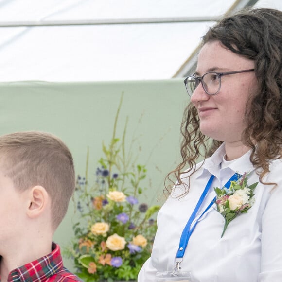 Charles III discutant avec Oliver Keith, 8 ans, d'une couronne en papier qu'il vient de réaliser lors du Royal Horticultural Society of Aberdeen Flower Show à Duthie Park, Aberdeen, en Ecosse. © Alpha Press/Bestimage