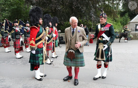 Le roi Charles III d'Angleterre, accueilli par des soldats de la compagnie Balaklava, 5e bataillon du Royal Regiment of Scotland devant le château de Balmoral (Ecosse), où le souverain débute ses vacances d'été, le 19 août 2024. 