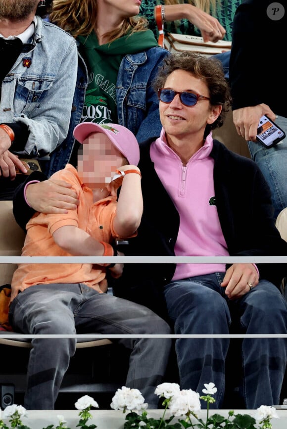 Le chanteur Raphaël, et son fils Aliocha Haroche dans les tribunes des Internationaux de France de tennis de Roland Garros 2024 à Paris, le 29 mai 2024.