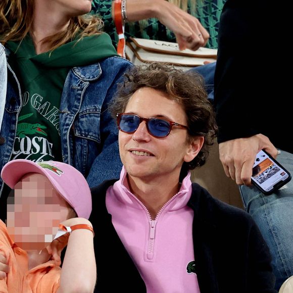 Le chanteur Raphaël, et son fils Aliocha Haroche dans les tribunes des Internationaux de France de tennis de Roland Garros 2024 à Paris, le 29 mai 2024.