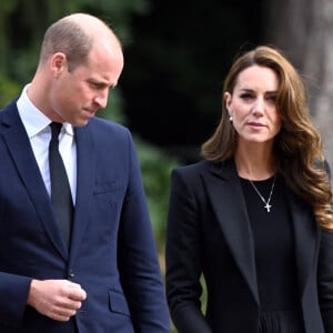 Le prince William, prince de Galles, et Catherine (Kate) Middleton, princesse de Galles regardent les hommages floraux laissés par les membres du public aux portes de Sandringham House à Norfolk, Royaume Uni, après la mort de la reine Elisabeth II.