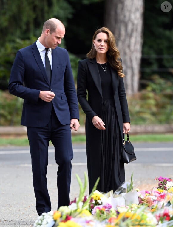 Le prince William, prince de Galles, et Catherine (Kate) Middleton, princesse de Galles regardent les hommages floraux laissés par les membres du public aux portes de Sandringham House à Norfolk, Royaume Uni, après la mort de la reine Elisabeth II.