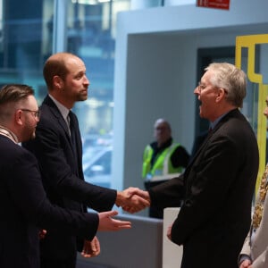 Le prince de Galles est accueilli par la secrétaire d'État à l'Irlande du Nord, Hilary Benn (deuxième à droite), et le maire de Belfast, Micky Murray (à droite), alors qu'il arrive pour une visite au centre du campus de la ville de Belfast de l'université d'Ulster, afin d'entendre parler des travaux qui sont menés pour consolider l'Irlande du Nord en tant que leader mondial de l'excellence créative et de l'innovation, en développant et en perfectionnant la future main-d'oeuvre et en développant les capacités technologiques.