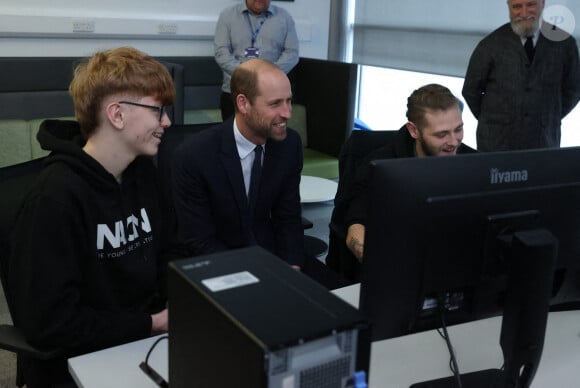 Le prince de Galles (au centre) rencontre un étudiant catholique et un étudiant protestant qui participent à un atelier de formation avec des jeunes des deux communautés à qui l'Ulster Screen Academy apprend à utiliser des logiciels utilisés dans la création de jeux, d'animations et de productions virtuelles, lors d'une visite à l'Ulster University's Belfast City Campus Centre, pour s'informer sur les travaux menés pour consolider l'Irlande du Nord en tant que leader mondial de l'excellence créative et de l'innovation en développant et en perfectionnant la future main-d'oeuvre et en développant les capacités technologiques.