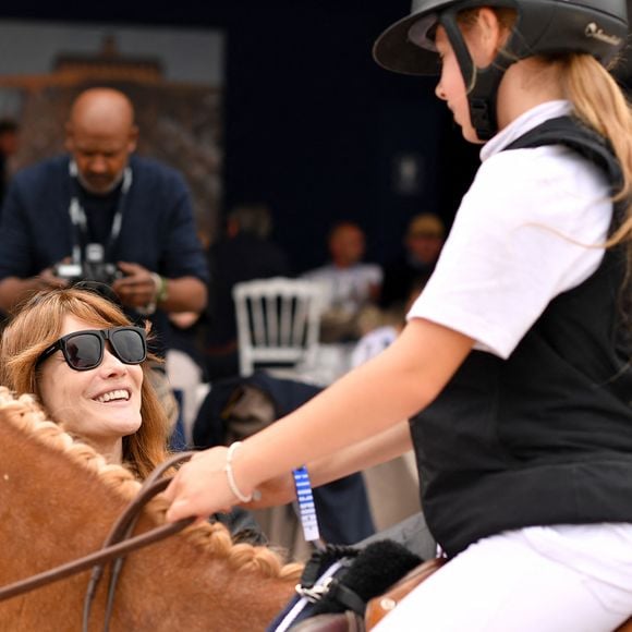 Carla Bruni Sarkozy et sa fille Giulia - N.Sarkozy et sa femme C.Bruni viennent soutenir leur fille G.Sarkozy pendant l'épreuve Kids Cup L'Envol lors de la 10ème édition du "Longines Paris Eiffel Jumping" à la Plaine de Jeux de Bagatelle à Paris, France, le 21 juin 2024. © Perusseau-Veeren/Bestimage 