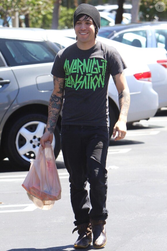 Pete Wentz offre un sac de denrées alimentaires à un homme dans le besoin, à Los Angeles, dimanche 22 août.