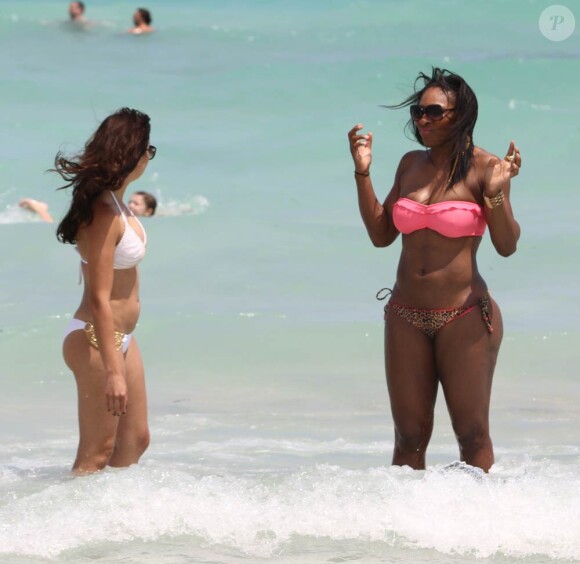Serena Williams sur la plage de Miami, le 16 avril 2011, en compagnie d'une amie, et de ses gardes du corps, jamais très loin.