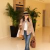 Michelle Yeoh à l'aéroport de Singapour avec le D-Bag, le T-Bag, la veste en daim Tod's by Derek Lam, les lunettes de soleil et les sandales en cuir marron chocolat... Le tout made in TOD'S !
