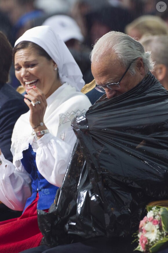 Séquence gag : le roi Carl XVI Gustaf de Suède a dû enfiler un poncho-poubelle lors du concert donné pour l'anniversaire de sa fille Victoria.
La princesse Victoria de Suède fêtait le 14 juillet 2011 son 34e anniversaire, sous la pluie mais dans la bonne humeur, entourée de son époux le prince Daniel, de ses parents le roi Carl GXVI Gustaf et la reine Silvia, de son frère le prince Carl Philip et de sa soeur la princesse Madeleine.