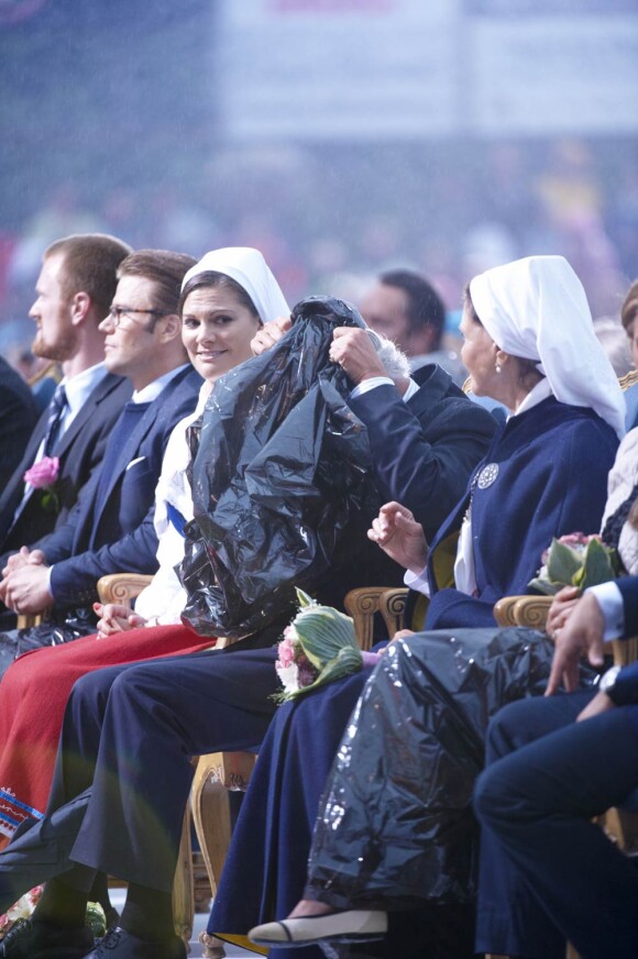Séquence gag : le roi Carl XVI Gustaf de Suède a dû enfiler un pncho-poubelle lors du concert donné pour l'anniversaire de sa fille Victoria.
La princesse Victoria de Suède fêtait le 14 juillet 2011 osn 34e anniversaire, sous la pluie mais dans la bonne humeur, entourée de son époux le prince Daniel, de ses parents le roi Carl GXVI Gustaf et la reine Silvia, de son frère le prince Carl Philip et de sa soeur la princesse Madeleine.