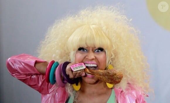 Nicki Minaj en concert à Central Park pour Good morning America sur ABC, le 5 août 2011. La chanteuse s'attaque à une cuisse de poulet... Que fait la PeTA ?