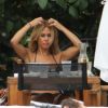Shauna Sand s'arrête dans un restaurant-snack au bord de la piscine pour grignotter, jeudi 11 août 2011 à Miami.