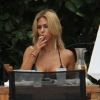 Shauna Sand s'arrête dans un restaurant-snack au bord de la piscine pour grignotter, jeudi 11 août 2011 à Miami.
