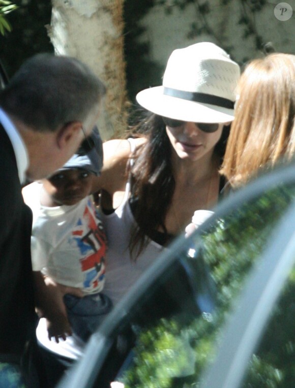 Sandra Bullock se précipite dans une limousine avec son fils adoptif Louis. Los Angeles, 3 août 2011