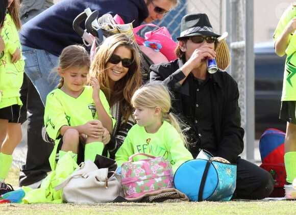 Charlie Sheen, Denise Richards et leur fille Lola soutiennent l'aînée Sam lors de son match de football, à Calabasas, le 19 novembre 2011. À la pause, la petite vient partager un encas avec ses parents. 