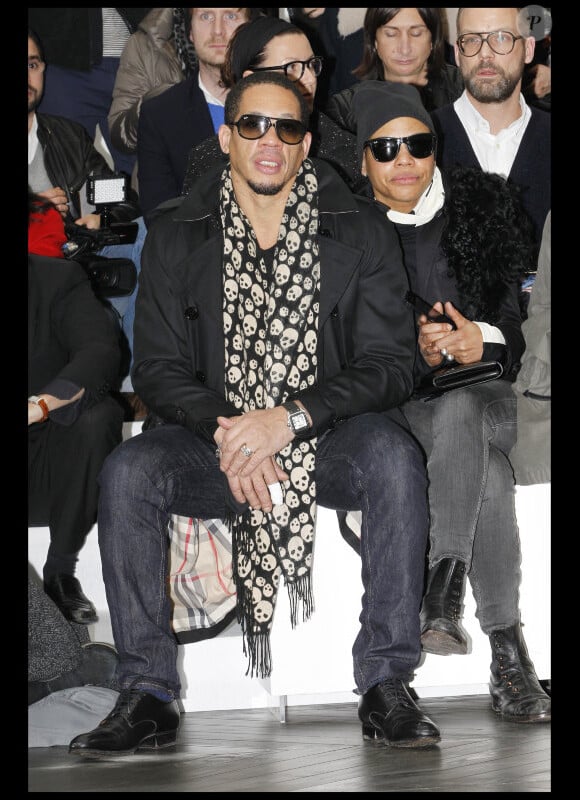 Le rappeur/acteur JoeyStarr était au premier rang du défilé Dior Homme à Paris, le 21 janvier 2012 avec une amie.