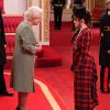 Sa majesté la reine Elizabeth II a remis les insignes de commandeur dans l'ordre de l'empire britannique à Helena Bonham Carter, vêtue d'une robe en tartan signée Vivienne Westwood, le 22 février 2012 à Buckingham Palace.