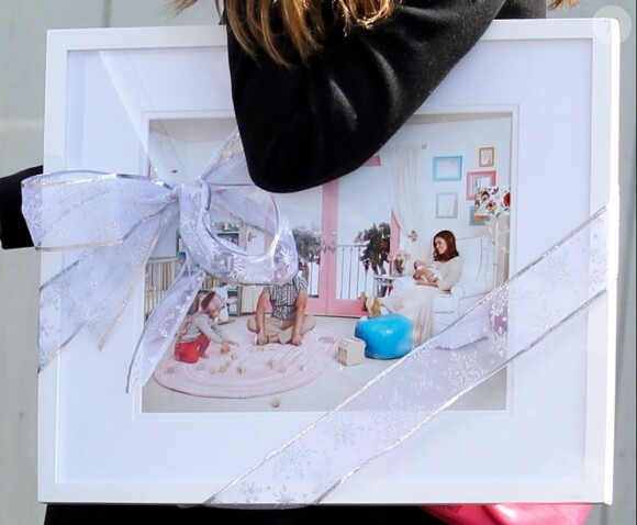 Jessica Alba se rend à son bureau, une photo de famille sous le bras. Los Angeles, le 20 mars 2012.
