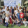 Fabrice Santoro et Michèle Laroque entourés des enfants lors du tournoi de tennis pour l'association Enfant Star et Match à Paris le 26 mars 2012