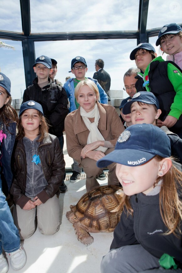 La princesse Charlene de Monaco pose avec des enfants et l'une des pensionnaires de L'Ile aux tortues, une tortue sillonnée, sur le toit du Musée océanographique de Monaco, le 24 avril 2012.