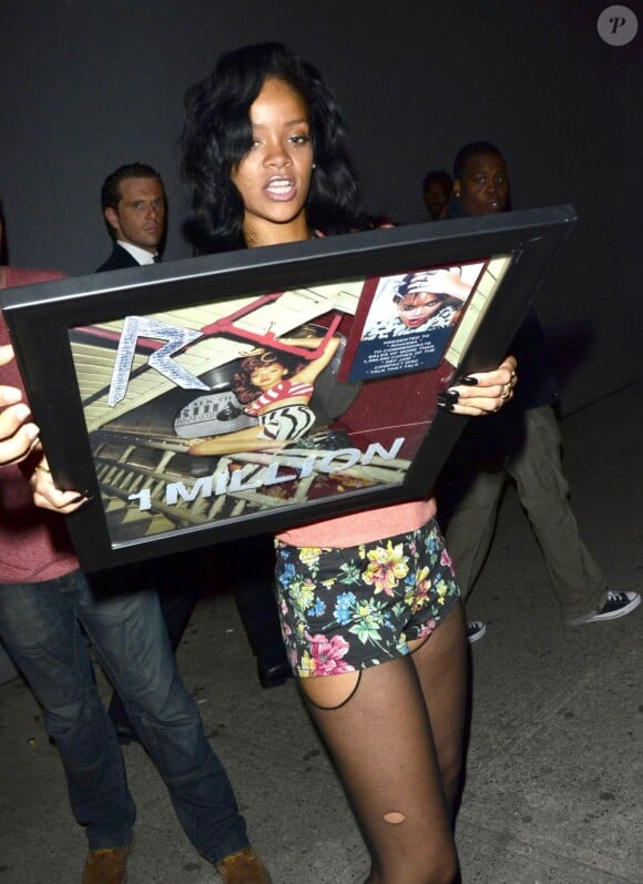 Rihanna à la sortie d'un studio d'enregistrement, son disque de platine entre les mains. New York, le 1er mai 2012.