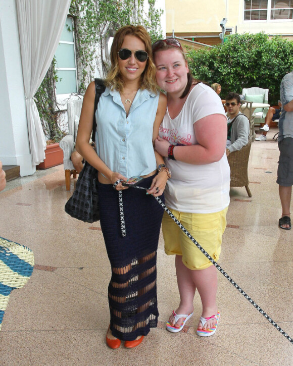 Miley Cyrus fait la rencontre d'une fan devant son hôtel de Miami, le mardi 15 mai 2012.