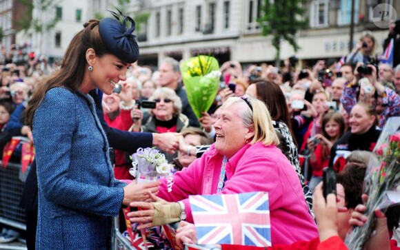 Kate Middleton, proche du peuple, accepte des fleurs lors de son passage au Old Market Square à Nottingham. Le 13 juin 2012.