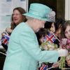 La reine Elizabeth II, habillée d'un chapeau et d'un manteau turquoise, arrive à la gare de Nottingham. Le 13 juin 2012.
