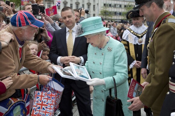 La reine Elizabeth II accepte les fleurs et cadeaux de ses sujets lors de son passage au Old Square Market de Nottingham, le 13 juin 2012.
