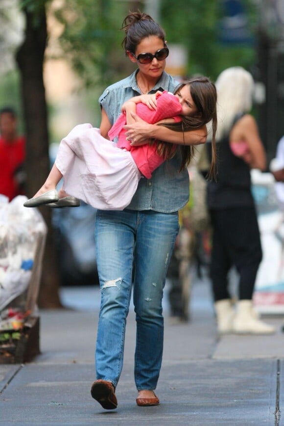 Suri Cruise, visiblement mécontente, se fait porter comme un petit bébé par sa mère Katie Holmes. New York, le 25 juin 2012.