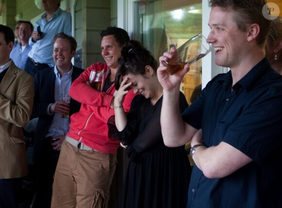 Lily Allen et son époux Sam Cooper à l'inauguration d'un club de cricket près de Londres le 8 juillet 2012. La chanteuse porte une robe noire et affiche quelques rondeurs.