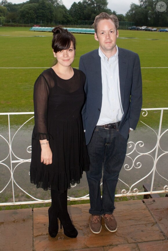 Lily Allen et son époux Sam Cooper à l'inauguration d'un club de cricket près de Londres le 8 juillet 2012. La chanteuse porte une robe noire et affiche quelques rondeurs.