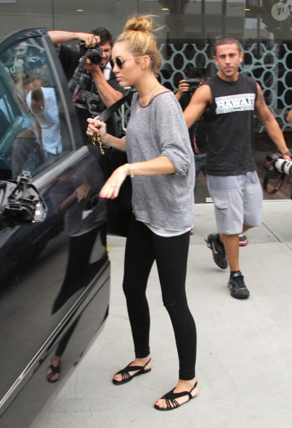 Toujours suivie par des paparazzi, Miley Cyrus sort d'une séance de sport et montre son nouveau tatouage sur son avant-bras, le 12 juillet 2012 à Los Angeles