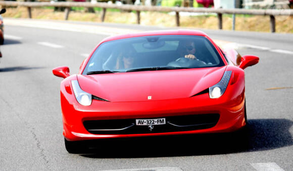 Christian Audigier à bord de son coupé Ferrari, à Saint-Tropez avec sa compagne Nathalie Sorensen, le dimanche 29 juillet 2012.