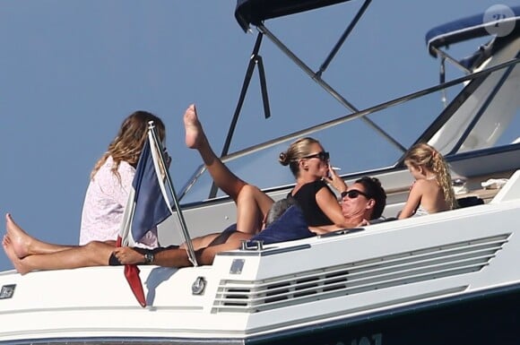 Fumant une cigarette devant sa fille Lila Grace, Kate Moss profite de ses vacances tropéziennes avec une balade en bateau. Saint-Tropez, le 17 août 2012.