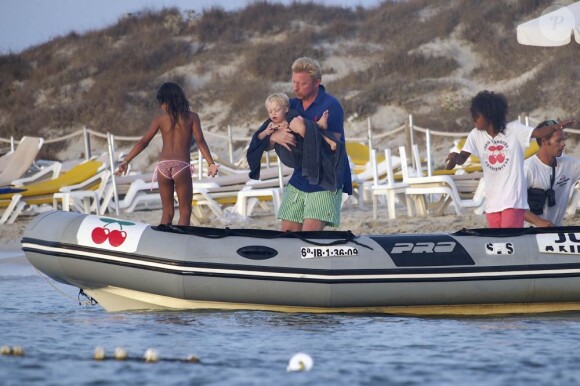 Boris Becker embarque avec son fils Amadeus dans ses bras sur l'île de Formentera le 17 août 2012