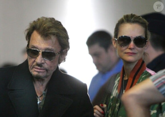 Le rockeur Johnny Hallyday et Laeticia à leur arrivée à l'aéroport de Paris Charles-de-Gaulle, le 9 octobre 2012.