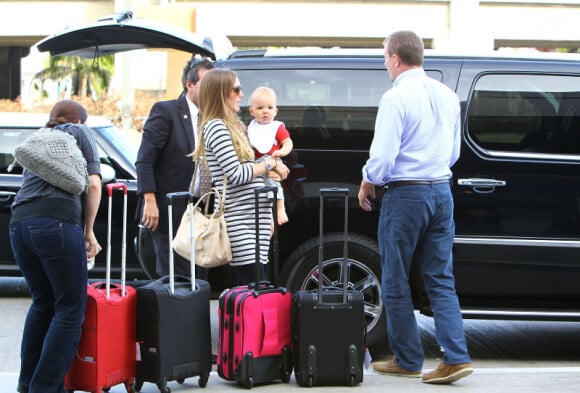 Guy Ritchie et sa fiancée Jacqui Ainsley, cernés par les valises, à l'aéroport Lax de Los Angeles, en compagnie de leur petit Rafael, le mardi 9 octobre 2012.