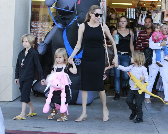 Angelina Jolie emmène trois de ses enfants faire du shopping pour Halloween le 28 octobre 2012 à Sherman Oaks en Californie dans le magasin Party City : elle porte dans ses bras son fils Knox
